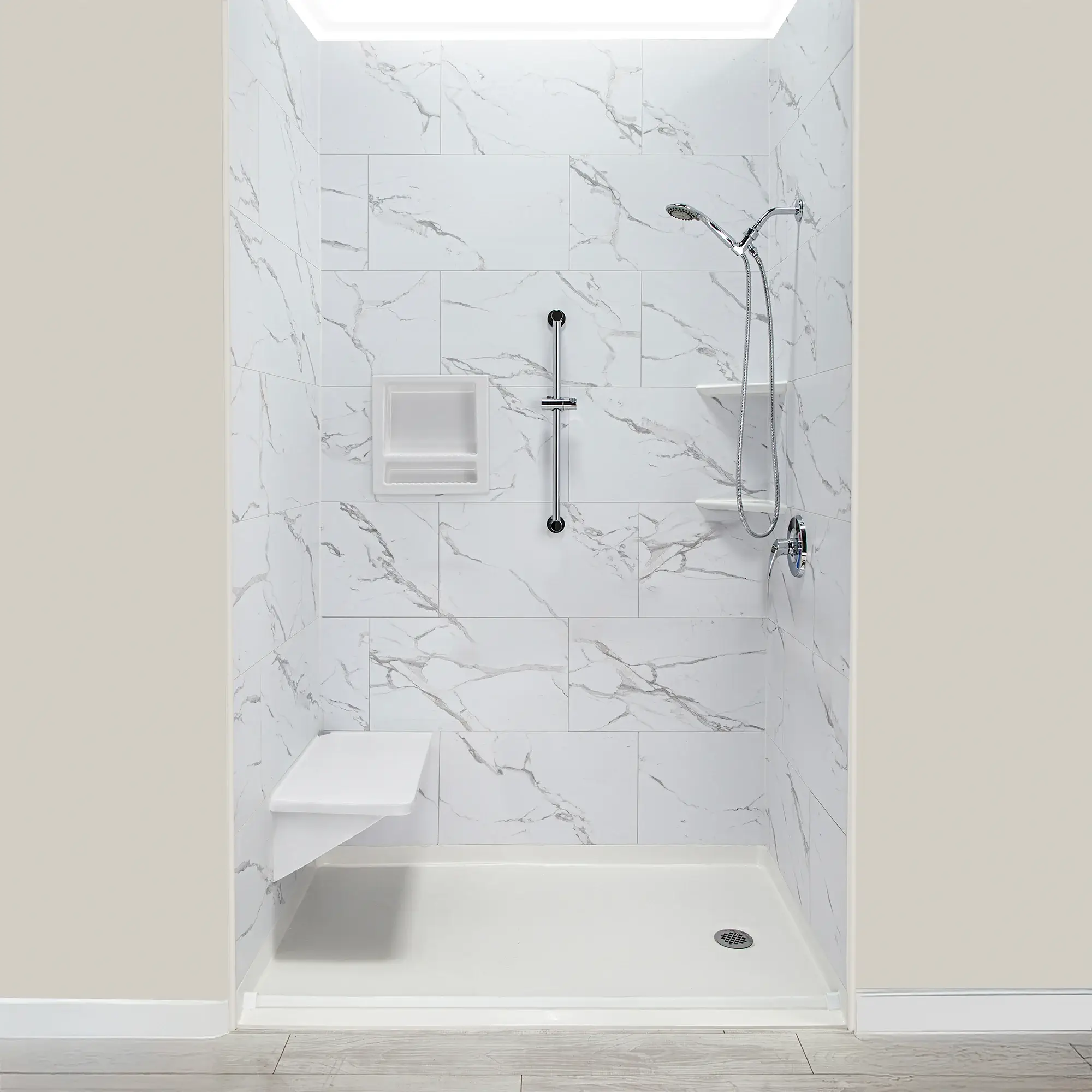 Low-threshold walk-in shower with grab bars and a built-in seat in a marble-tiled bathroom